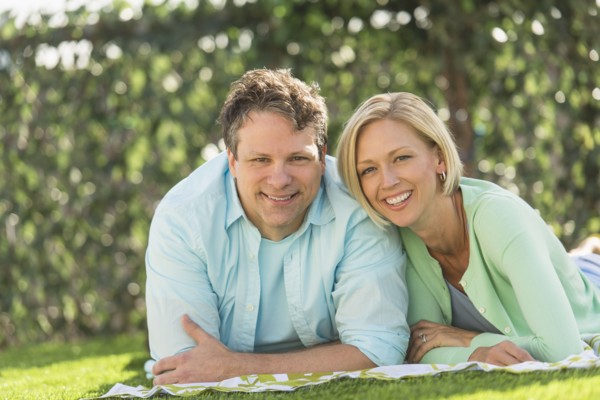 Couple lying on grass.