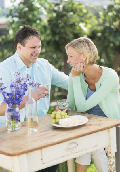 Couple sitting at table outdoors.