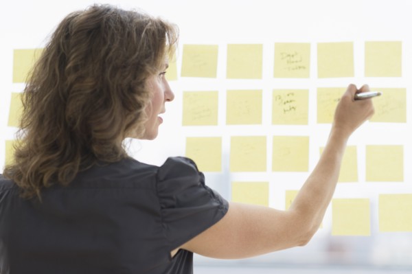Business woman arranging yellow notes.