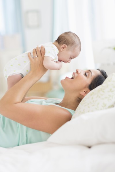 Mother playing with baby (2-5 months).