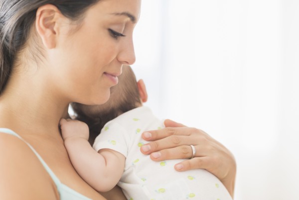 Mother holding baby boy (2-5 months).