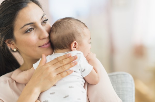 Mother embracing baby boy (2-5 months).