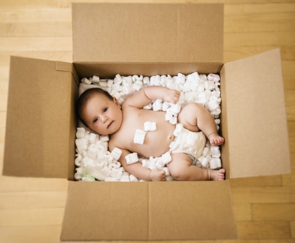 Baby girl (2-5 months) in cardboard box.
Photo : Jamie Grill