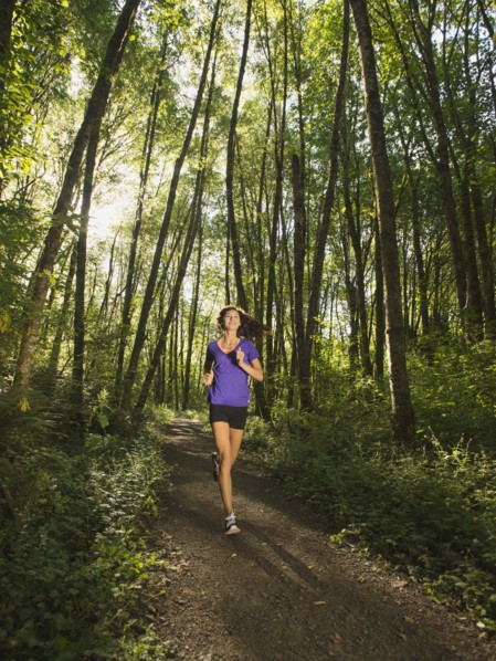 Young woman jogging in forest. USA, Oregon, Portland.