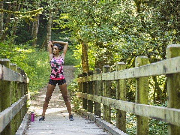 Young women stretching on footbridge. USA, Oregon, Portland.