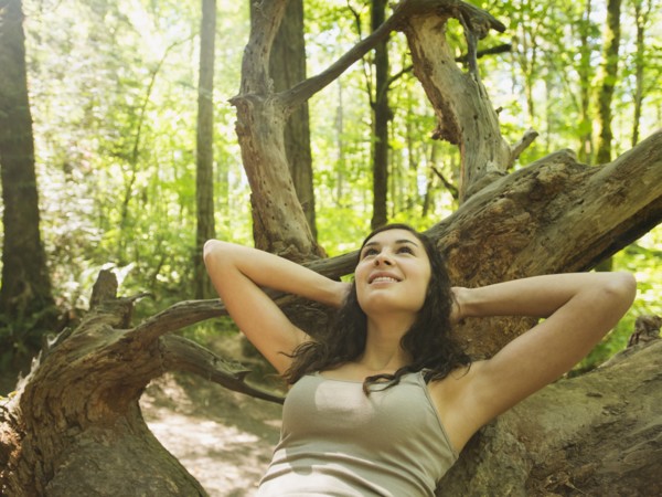 Portrait of young woman lying down on log. USA, Oregon, Portland.