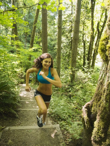 Young woman jogging in forest. USA, Oregon, Portland.