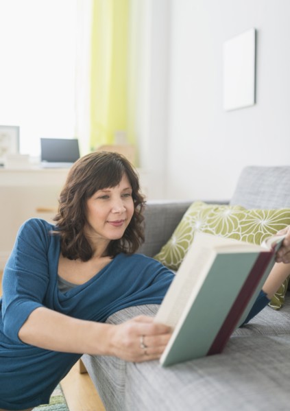 Woman reading book at home.