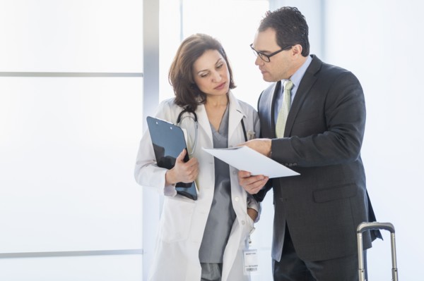 Pharmaceutical representative talking to female doctor.