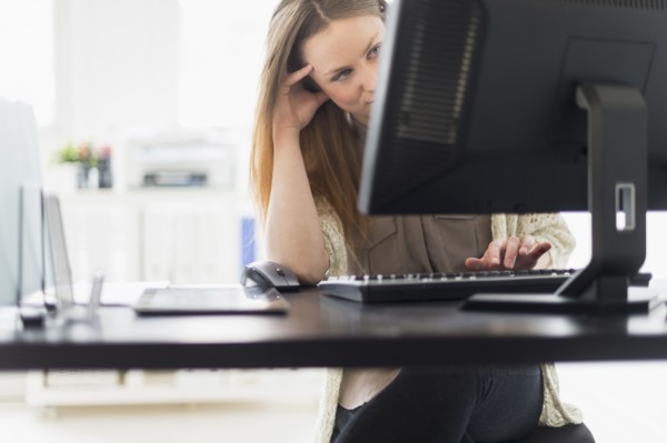 Portrait of young woman working on computer in office.
