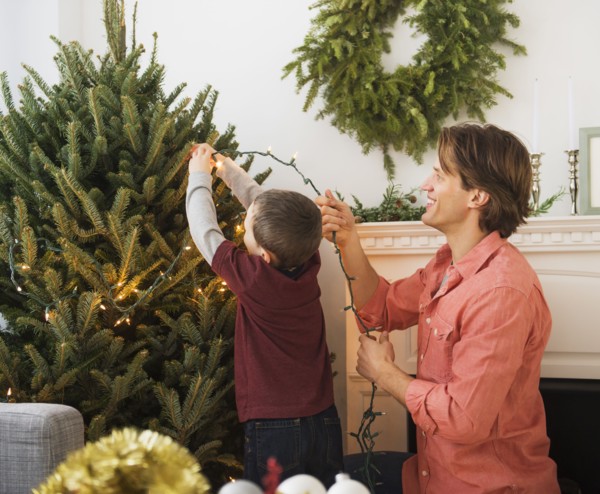 Man with kid (6-7) decorating Christmas tree.
Photo : Daniel Grill
