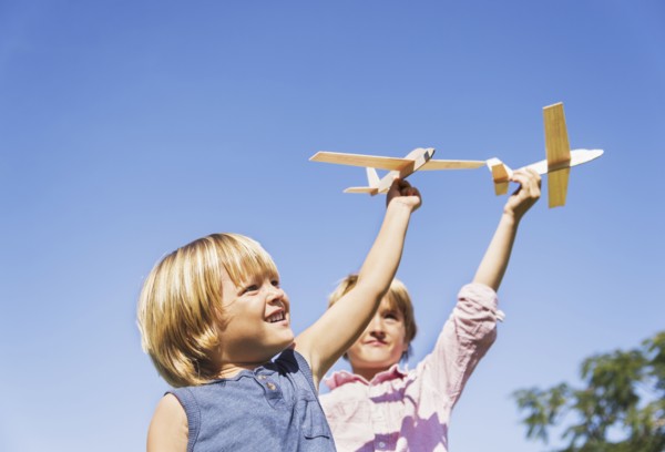 Boys (4-5, 8-9) playing with airplane toys.
Photo : Daniel Grill