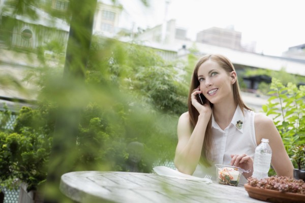 Portrait of young woman sitting on balcony and using mobile phone. New York City, USA.
Photo :