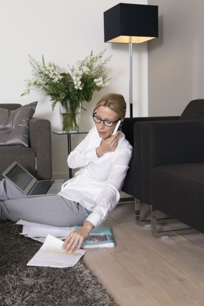 Woman sitting on floor and talking on mobile.
Photo : Mark de Leeuw