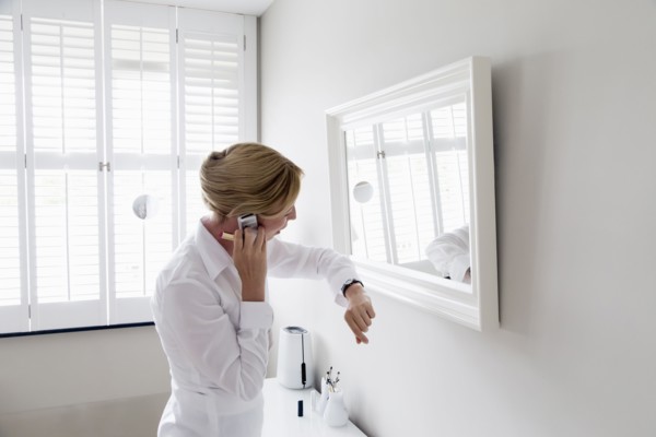 Woman checking time and talking on mobile.
Photo : Mark de Leeuw