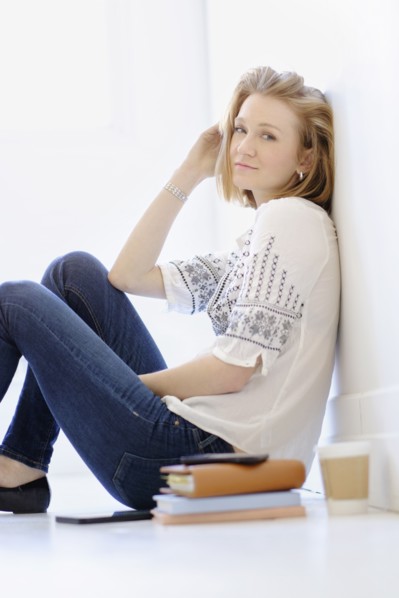 Portrait of young woman sitting on floor.