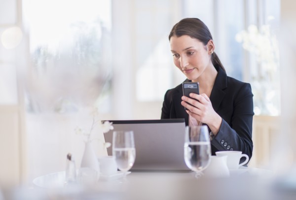 Businesswoman working on laptop in restaurant.