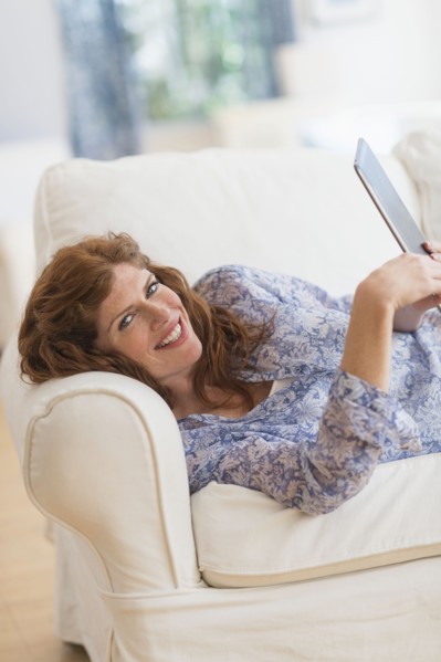 Woman lying on sofa and using laptop.