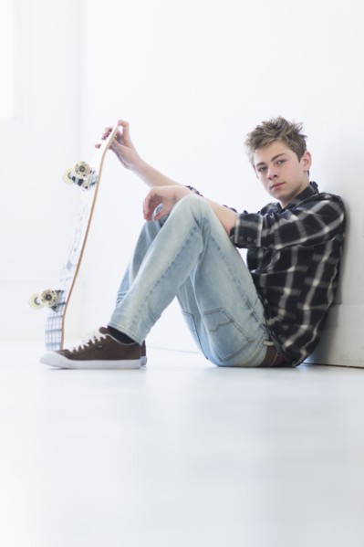 Teenage boy (16-17) holding skateboard.