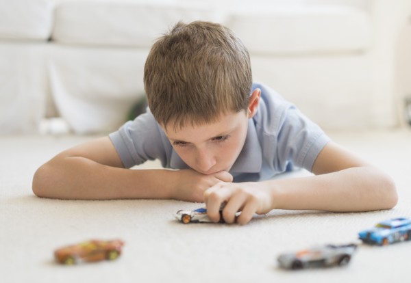 boy (8-9) playing with toy cars.