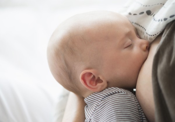Close up of baby boy (2-5 months) suckling mother's breast.