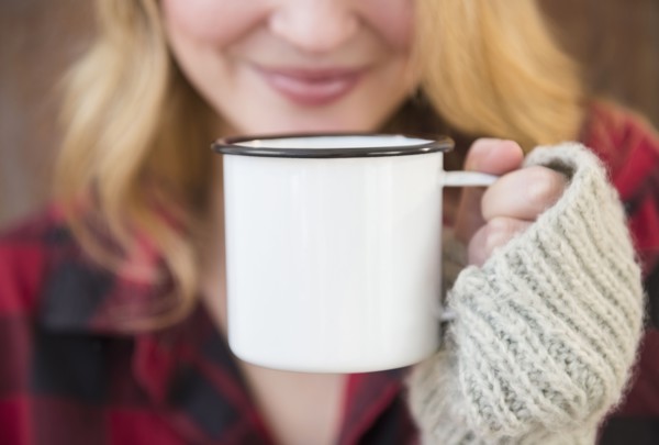 Woman holding metal coffee mug.
Photo : Jamie Grill
