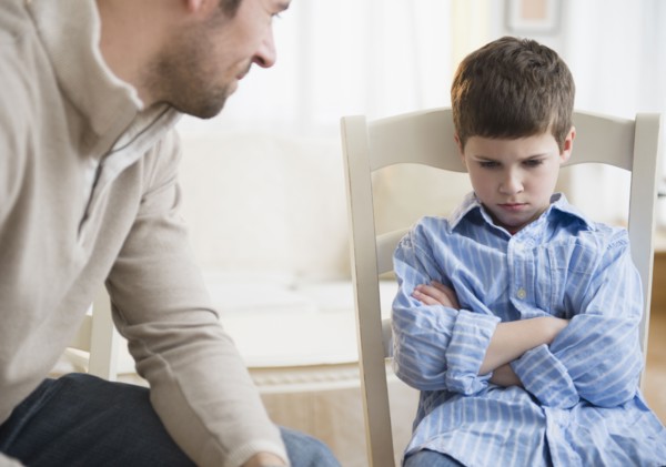 Father looking at displeased son (8-9) .
Photo : Jamie Grill