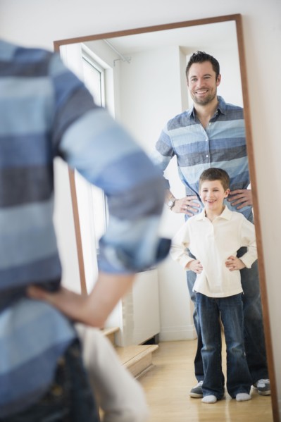 Father and son (8-9) looking at their reflection in mirror.
Photo : Jamie Grill