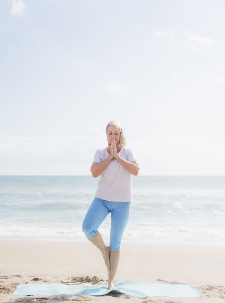 Senior woman practicing yoga on beach.
Photo : Daniel Grill