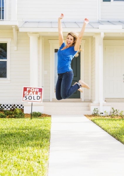Woman jumping in front of new house.
Photo : Daniel Grill