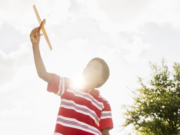 boy (6-7) playing with toy airplane.
Photo : Daniel Grill