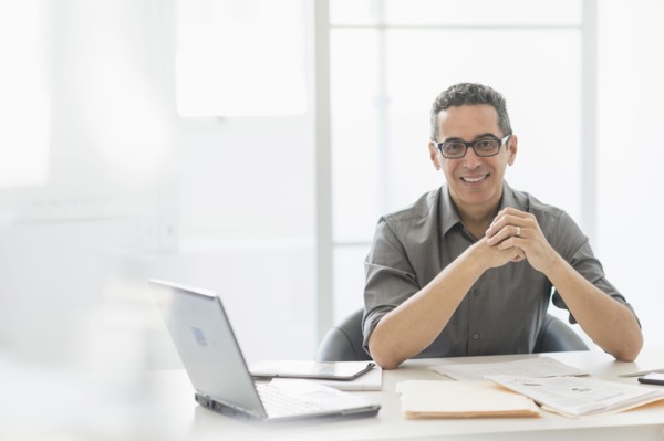 Portrait of man at desk in office.