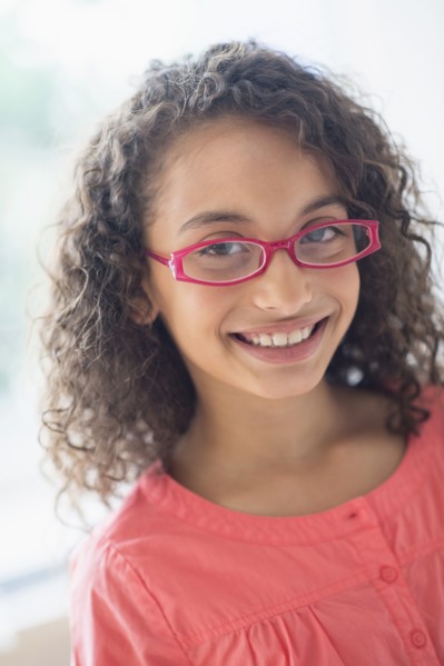 Portrait of schoolgirl (8-9) wearing pink eyeglasses.