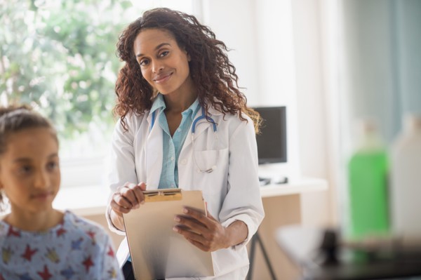 Female doctor examining girl (8-9).