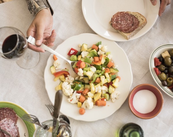 Hand serving salad.