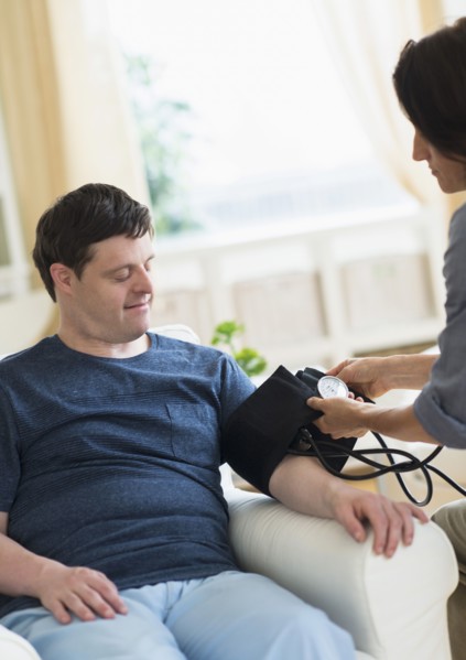 Man with down syndrome having blood pressure measured.