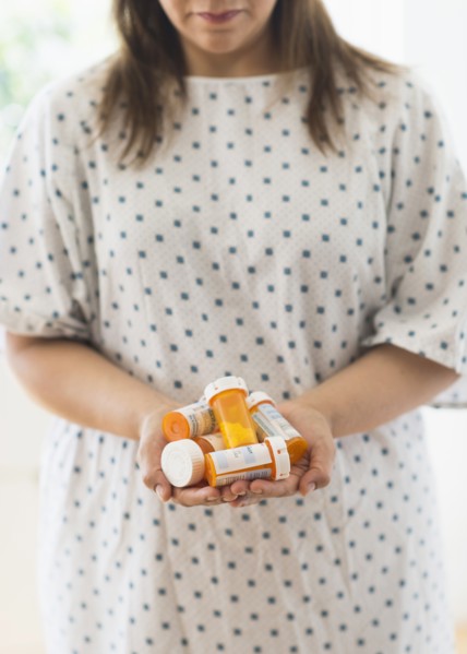 Woman with pill bottles in hands.