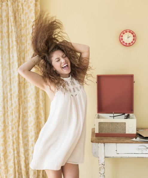 Portrait of woman dancing happily in room.