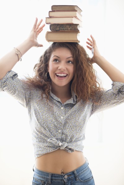 Portrait of woman with books on top of head.
