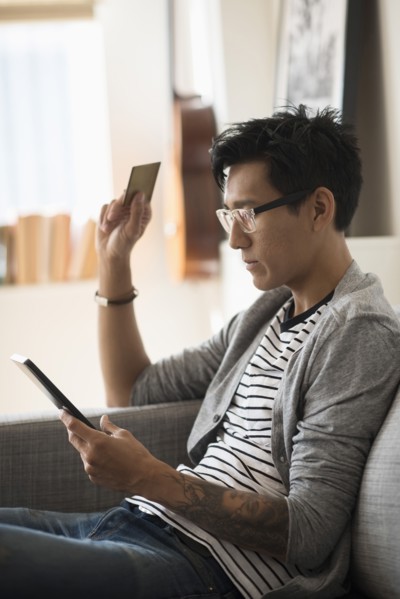 Man paying with credit card on tablet.