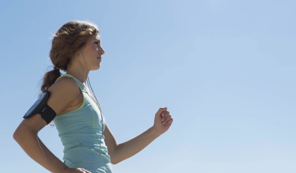 Side view of young woman jogging.