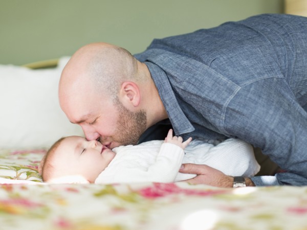 Studio shot of father kissing his son (2-5 months)