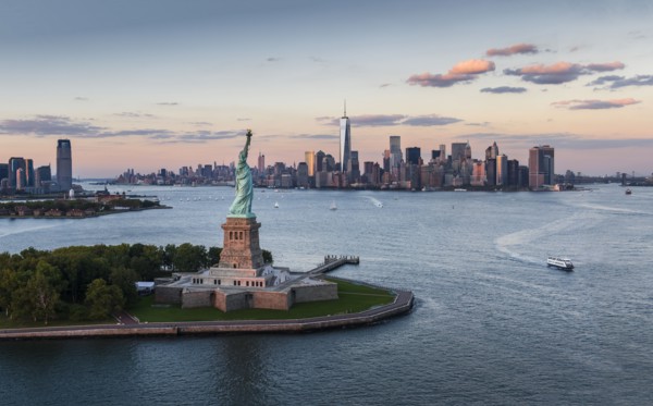 Aerial view of city with Statue of Liberty at sunset. New York City, New York.