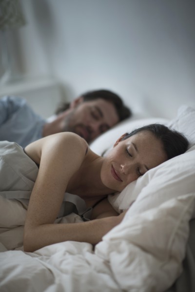 Couple sleeping together in bed at night.