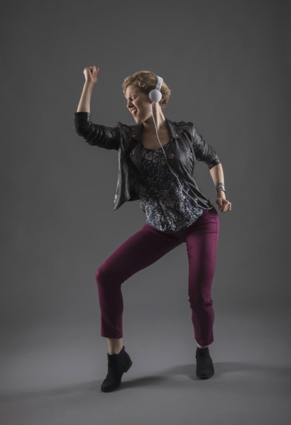 Studio shot of woman listening to music and dancing.