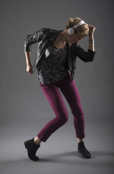 Studio shot of woman listening to music and dancing.