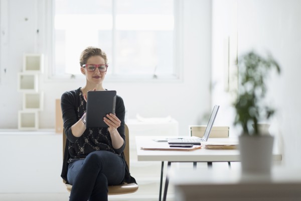 Businesswoman using digital tablet in office.