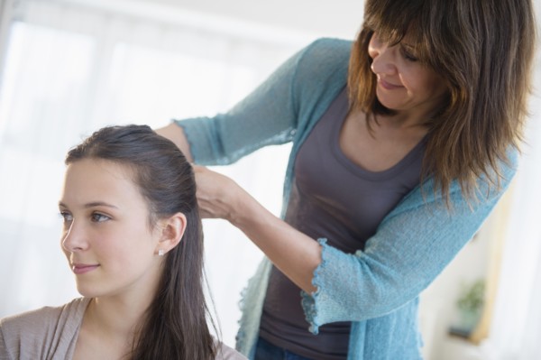 Mom tying up daughter's (14-15) hair