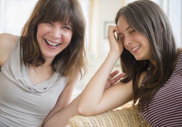 Portrait of mom and teenage girl (14-15) laughing at home