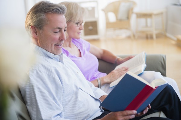 Portrait of couple sitting on sofa reading books
